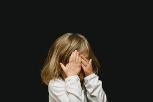 child covering their eyes because they're scared of the dark