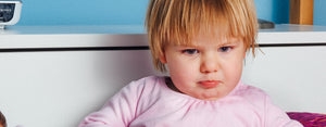 Image contains a photo of a young child with a grumpy face that needs to learn emotional self-regulation.