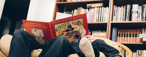 Image contains a photo of an adult reading a book to a child, which can help with the child's development.