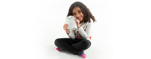 Image contains a photo of a young girl hugging Snorble®, a smart robot for kids.